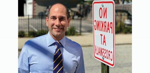 普罗维登斯市议员大卫·塞尔瓦托站在“人行横道禁止停车”的标志旁边