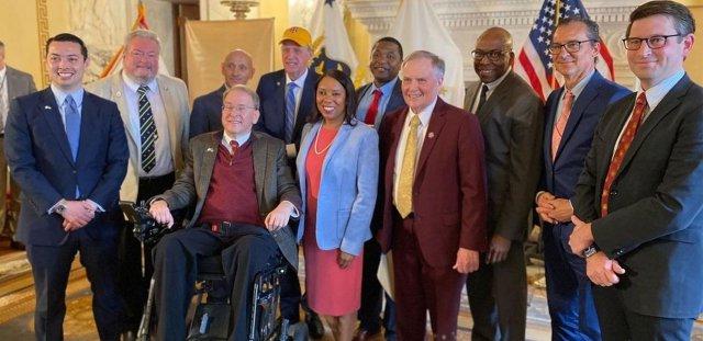 A large group of state leaders, including RIC President Warner, 政府. McKee and former Congressman James Langevin gather in the 政府ernor's State Room at the RI State House.